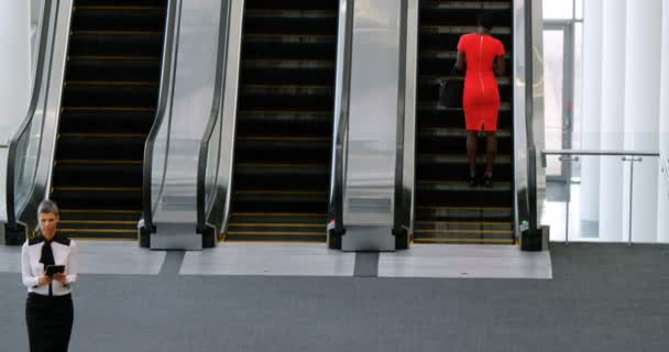 女实业家使用手机在自动扶梯在办公室4K — 图库视频影像