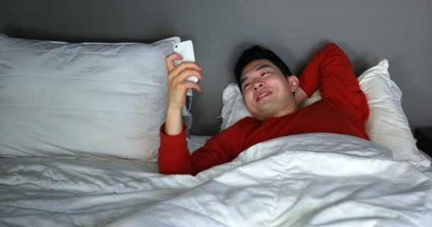 Man Met Mobiele Telefoon Bed Bij Huis — Stockvideo