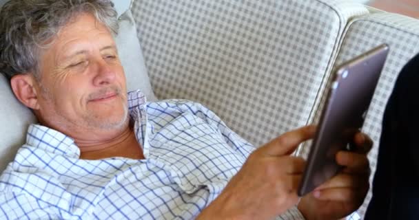 Senior Man Met Digitale Tablet Liggend Bank Veranda Thuis — Stockvideo