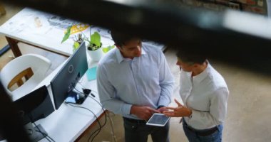 Office Yöneticiler Office 4 k dijital tablet üzerinde tartışırken Yüksek açılı görünüş
