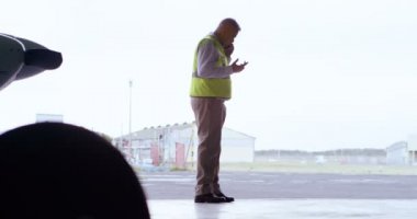 Havacılık ve uzay hangarda 4 k cep telefonu konuşurken erkek mühendis