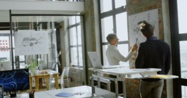 Araba tasarımcıları araç üzerinde tartışırken Office 4 k tasarım kroki