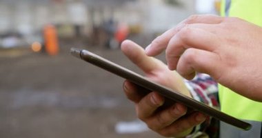 Orta bölüm erkek işçinin hurdalıkta 4 k dijital tablet kullanma