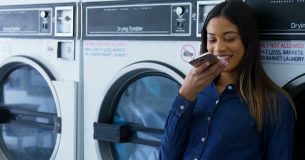 Smiling Woman Talking Mobile Phone Laundromat — Stock Video