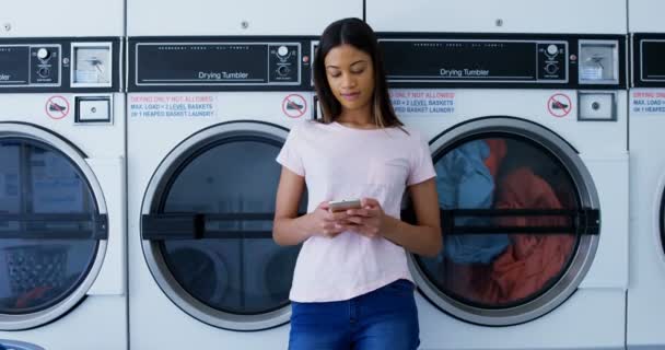 Hermosa Mujer Usando Teléfono Móvil Lavandería — Vídeos de Stock