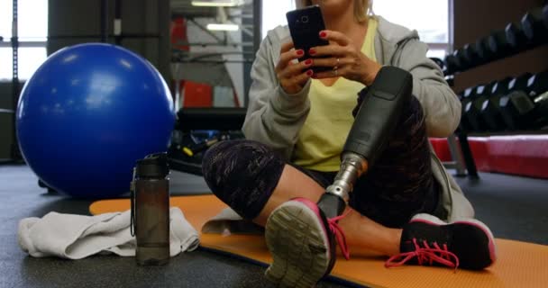 Χαμογελώντας Ανώτερος Γυναίκα Που Χρησιμοποιούν Κινητό Τηλέφωνο Στο Στούντιο Γυμναστικής — Αρχείο Βίντεο