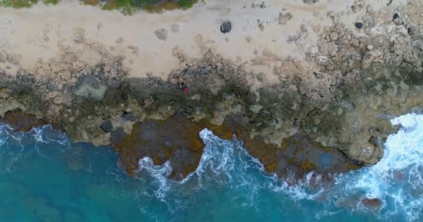 高视角的情侣坐在岩石海岸4K — 图库视频影像