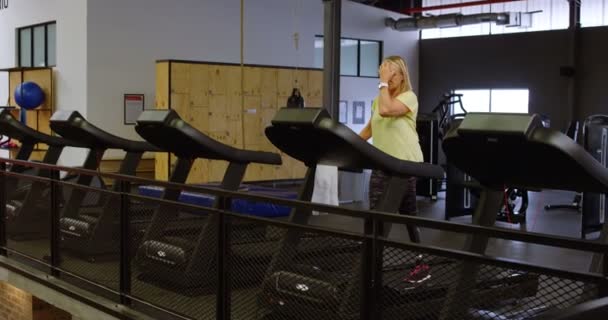 残疾妇女在跑步机上做运动在健身室4K — 图库视频影像