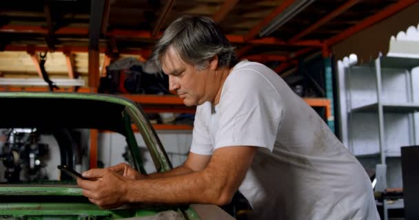 Male Mechanic Using Mobile Phone Garage — Stock Video