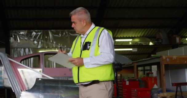 Ingeniero Masculino Escribiendo Portapapeles Hangar Aeroespacial — Vídeo de stock