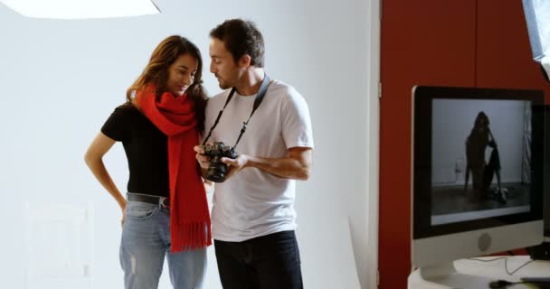 男摄影师和模特在摄影棚里讨论照片4K — 图库视频影像