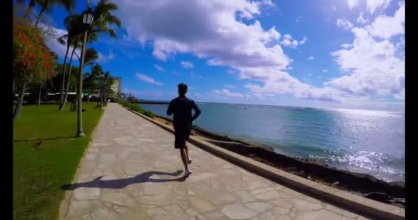 Άνθρωπος Που Τρέχει Στον Περίπατο Στην Παραλία Μια Ηλιόλουστη Ημέρα — Αρχείο Βίντεο