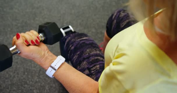 フィットネス スタジオ のダンベルで上腕二頭筋のワークアウトをしている年配の女性のオーバー ヘッド ビュー — ストック動画
