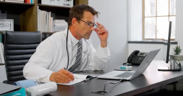 Médico Olhando Para Laptop Sua Mesa Clínica — Vídeo de Stock