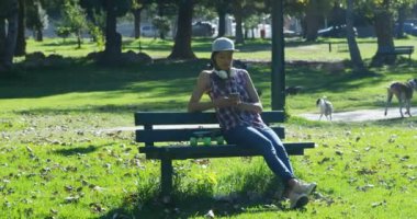 4 k parkta bankta cep telefonu kullanan kadın