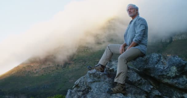 Hombre Mayor Activo Relajándose Una Roca Campo — Vídeos de Stock