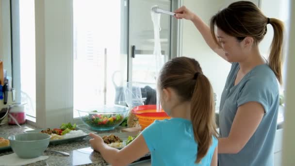 Donna Con Sua Figlia Che Tiene Noddle Sul Piatto Cucina — Video Stock