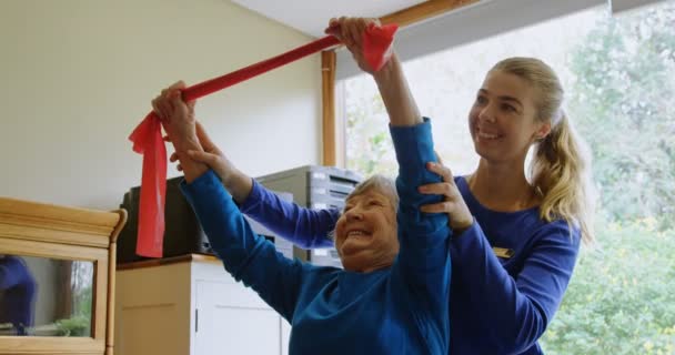 Физиотерапевт Исправляет Положение Пожилой Женщины Клинике — стоковое видео