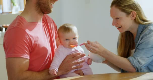 Gelukkige Ouders Voeden Hun Baby Bij Huis — Stockvideo