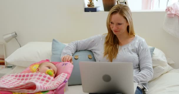 Moeder Baby Kijken Terwijl Het Gebruiken Van Laptop Huis — Stockvideo
