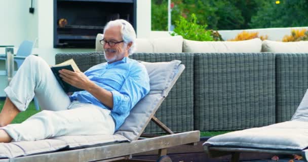 Actieve Senior Man Lezen Van Een Boek Tuin — Stockvideo