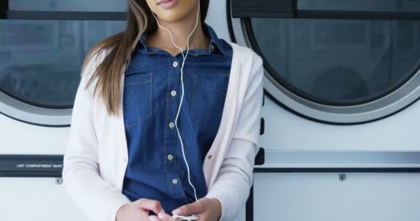 Gelukkige Vrouw Luisteren Muziek Mobiele Telefoon Bij Wasserette — Stockvideo