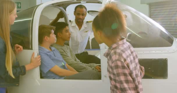 男飞行员在培训学院向孩子解释飞机的情况4K — 图库视频影像