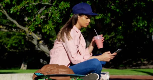 Mulher Usando Telefone Celular Enquanto Toma Suco Dia Ensolarado — Vídeo de Stock
