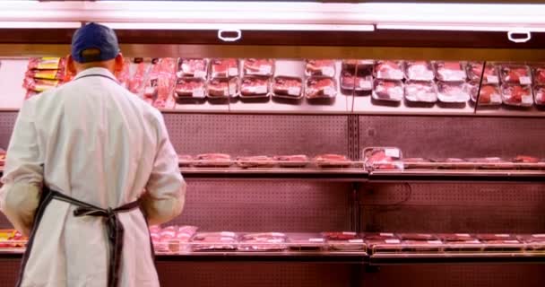 Vista Posteriore Del Macellaio Che Organizza Carne Avvolta Rack Presso — Video Stock