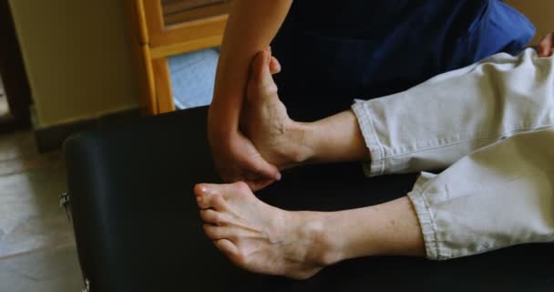 理疗师对4K 临床老年妇女进行腿部治疗 — 图库视频影像
