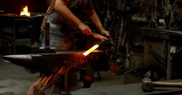 Herrero Examinando Una Varilla Metal Caliente Con Cepillo Taller — Vídeo de stock