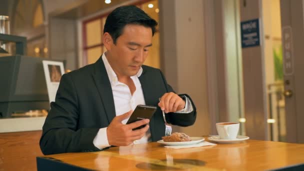 Επιχειρηματία Έχοντας Τροφίμων Ενώ Χρήση Κινητού Τηλεφώνου Στο Καφέ — Αρχείο Βίντεο