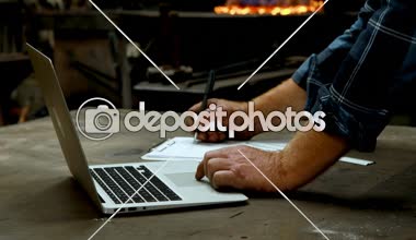 Close-up atölye 4 k laptop kullanırken panoya yazma demirci