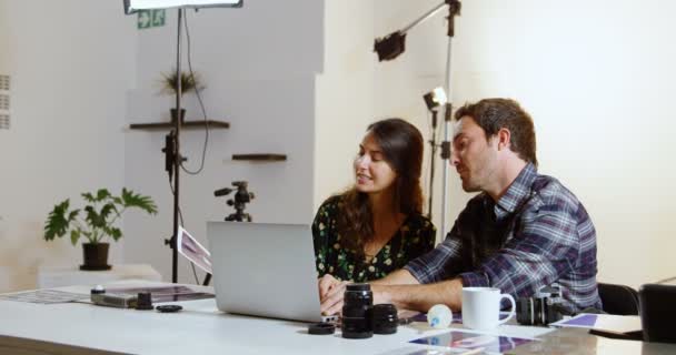 Fotógrafos Discutiendo Sobre Ordenador Portátil Escritorio Estudio Fotos — Vídeos de Stock