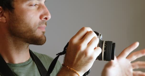 男摄影师点击照片与相机在摄影棚4K — 图库视频影像
