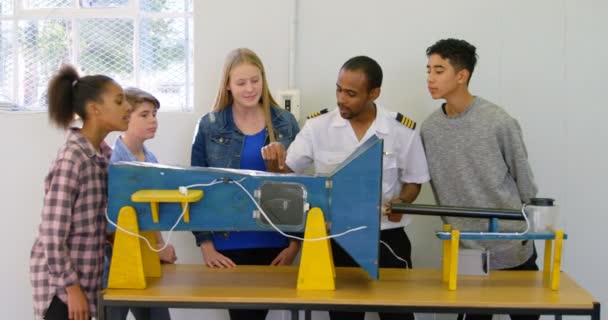 男飞行员在培训学院向孩子讲解机器的情况4K — 图库视频影像