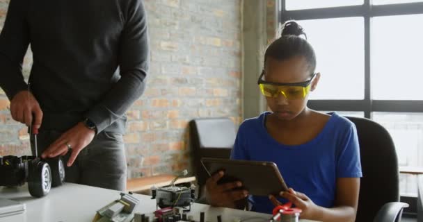 Hija Usando Tableta Digital Mientras Padre Reparando Coche Eléctrico Oficina — Vídeo de stock