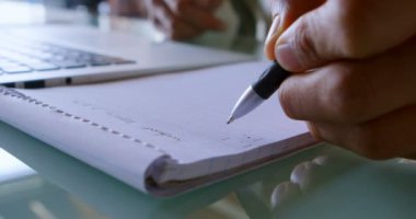 Not etmek üstünde laptop evde kullanırken 4 k yazma adam Close-up