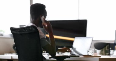 Erkek executive Office 4 k cep telefonunda konuşurken dizüstü bilgisayar kullanarak