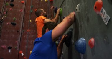 Erkek ve kadın bouldering spor salonunda 4 k yapay duvar tırmanışı