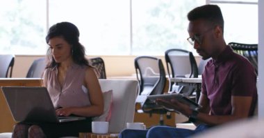 Yöneticiler Office 4 k kanepede dizüstü bilgisayar ve dijital tablet kullanarak