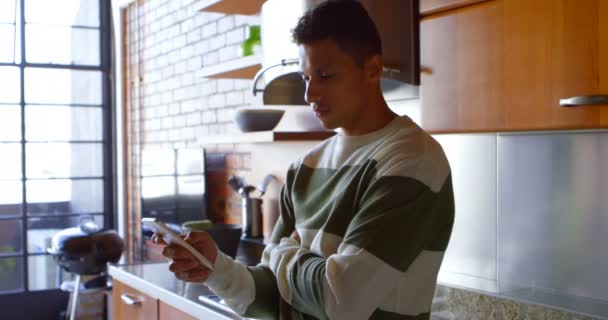 Hombre Usando Teléfono Móvil Cocina Casa — Vídeos de Stock