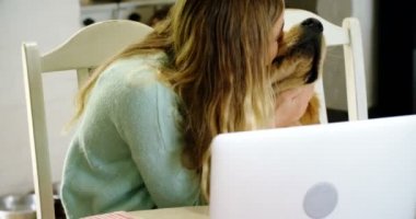 Kadın köpeğini dizüstü evde kullanırken 4 k oynamak
