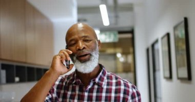 Office 4 k cep telefonu konuşurken üst düzey erkek yönetici