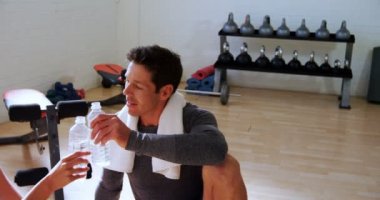 gülümseyen erkek ve kadın su şişeleri 4 k spor salonunda kızartma