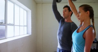 Erkek ve kadın ile kettlebells 4 k spor salonunda egzersiz