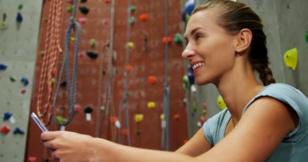 Lachende Vrouw Met Behulp Van Mobiele Telefoon Boulderen Sportschool — Stockvideo