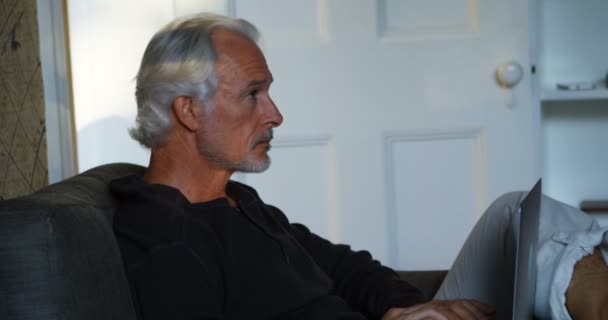 Tankeväckande Senior Man Använder Laptop Soffan Vid Hem — Stockvideo