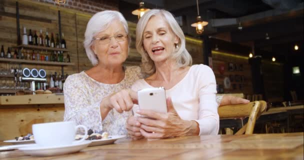 Δύο Ανώτεροι Γυναίκα Συζήτηση Πέρα Από Τηλέφωνο Στο Καφέ — Αρχείο Βίντεο