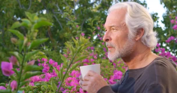 思いやりのある年配の男性 Homeyard でコーヒーを飲んで — ストック動画